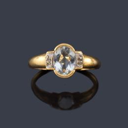 Lote 2269: Anillo con aguamarina talla oval y dos diamantes sobre montura de oro amarillo de 18K.