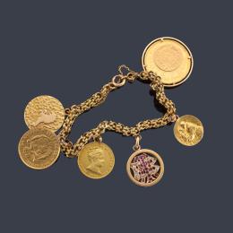 Lote 2449: Pulsera con tres monedas en oro de 22 K y tres colgantes, medalla, placa con signo del zodiaco y colgante con rubíes y diamantes talla rosa, realizado en oro amarillo de 18K.