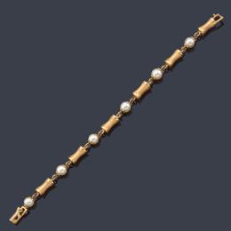 Lote 2469: Pulsera con perlas intercalado con eslabones de diseño cónico en oro amarillo de 18K.