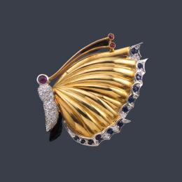 Lote 2540: Broche con motivo de mariposa con brillantes, rubíes y zafiros con diseño de gallonado en las alas.