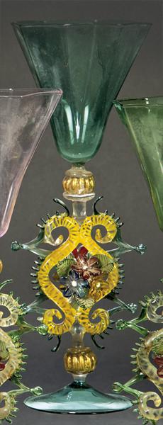 Lote 1095
Copa de cristal de Murano verde oscuro con depósito poligonal y vástago con eses adosadas, crestería y flores.