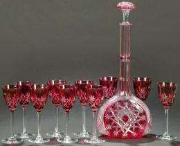 Lote 1512: Juego de licorera y diez copas de licor de cristal de Bohemia tallado y parcialmente esmaltado en rojo.
