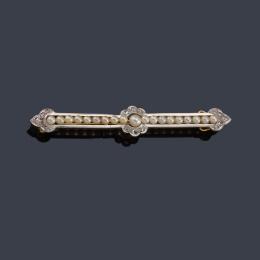 Lote 2040: Broche - barrita con centro en forma de rosetón con banda de perlitas y diamantes talla rosa, en montura de oro amarillo de 18K y vista en platino. Ppios S. XX.
