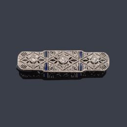 Lote 2080<br>Broche - placa con tres diamantes talla antigua central y zafiros calibrados, en montura de platino.
