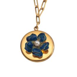 Lote 2144: Guardapelo circular con flor esmaltada en color azul y perla central con cadena en oro amarillo de 18K.