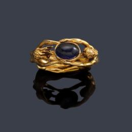 Lote 2152: CARRERA & CARRERA <br>Anillo con figura de hombre y mujer unidos por un zafiro talla cabujón, realizado en montura de oro amarillo de 18K.