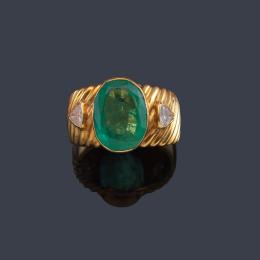 Lote 2443<br>Anillo con esmeralda talla oval de aprox. 3,20 ct con dos diamantes talla triángulo.