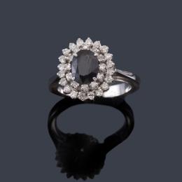 Lote 2501: Anillo con zafiro talla oval y doble orla de brillantes en montura de oro blanco de 18K.