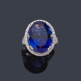 Lote 2508<br>Anillo con gran tanzanita talla oval de aprox. 14,91 ct con orla y brazos con brillantes de aprox. 1,10 ct en total.