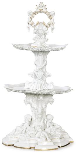 Lote 1081-A<br>Centro de mesa de dos alturas en cerámica esmaltada en blanco y parcialmente dorado.<br>Francia, S. XIX