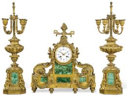 Lote 1122<br>Reloj de sobremesa con guarnición estilo Luis XVI en bronce y malaquita. Sobre un basamento poligonal se situa la esfera del reloj firmada RAINGO FRES