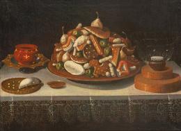 Lote 0084<br>TOMÁS HIEPES - Bodegón con bandeja de pasteles, fruta confitada, peladillas y otros objetos sobre una mesa con mantel bordado. c. 1640-1650
