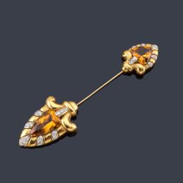 Lote 2139: LUIS GIL<br>Broche-aguja con dos citrinos talla triángulo y perilla de aprox. 16,84 ct con diseño de volutas y salpicado con brillantes.