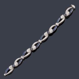 Lote 2150: Pulsera con diseño de ondas entrelazadas con zafiros calibrados de aprox. 2,80 ct y diamantes talla brillante de aprox. 9,00 ct y baguette de aprox. 1,00 ct en total.