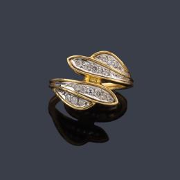 Lote 2392: Anillo con dos brazos contrapeados con diseño vegetal con brillantes en montura de oro amarillo de 18K y vista en oro blanco.