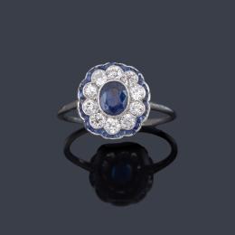 Lote 2059: Anillo con zafiro talla oval de aprox. 0,40 ct con orla de diamantes talla brillante y zafiros calibrados.