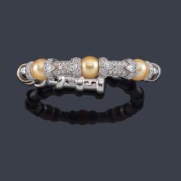 Lote 2149: Pulsera semirrígida con tres perlas 'Golden' intercalado con motivos cuajados de brillantes y diamantes talla perilla.