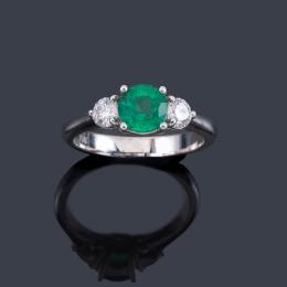 Lote 2457: Anillo con esmeralda talla redonda de aprox. 0,85 ct y dos brillantes de aprox. 0,40 ct en total.