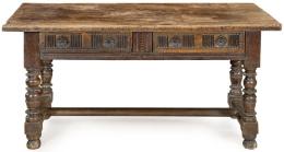 Lote 1118: Mesa de tapa rectangular en madera de nogal, con dos cajones en el frente, con decoración tallada, sobre montantes abalaustrados torneados unidos por chambranas rectas.<br>España, S. XVII<br>