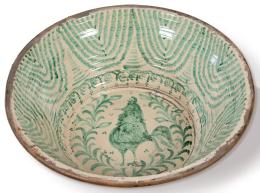 Lote 1258<br>Lebrillo en cerámica esmaltada verde de fajalauza con decoración de gallo enmarcado por motivos vegetales en el asiento y cenefa de cortinaje en el alero. <br>Granada, S. XX