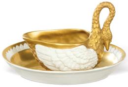 Lote 1276: Taza salsera Carl Thieme de Postchappel Dresden en forma de cisne. Esmaltada en blanco y parcialmente dorada. Acompañada de un plato oval a juego esmaltado y dorado. Ambas piezas cuentan con firma en la base. Alemania, principios del siglo XX.