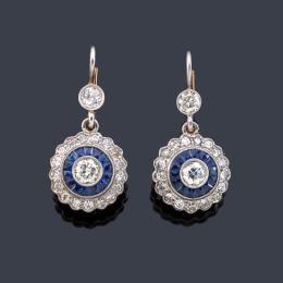 Lote 2075: Pendientes cortos 'ojo de perdiz' con pareja de brillantes y orla de diamantes de aprox. 1,50 ct en total, con zafiros calibrados.