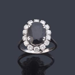 Lote 2323: Anillo con zafiro talla oval de aprox. 3,00 ct con orla de brillantes de aprox. 0,98 ct en total.