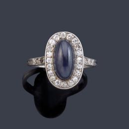 Lote 2330<br>Anillo con zafiro central talla cabujón de aprox. 3,36 ct con orla de diamantes talla 8/8 en montura de platino.