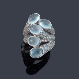 Lote 2462<br>Anillo con cinco piedras luna talla cabujón con pavé de topacios azules en los brazos.