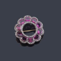 Lote 2001<br>Broche circular con rubelitas talladas con orla de diamantes talla rosa. S. XIX.