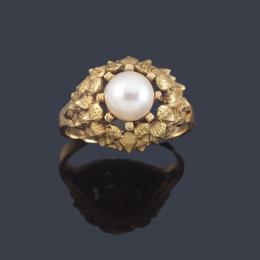 Lote 2205<br>Anillo con perla central sobre montura de oro amarillo de 18K con diseño vegetal.