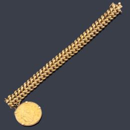 Lote 2289: Pulsera con doble eslabón realizado en oro amarillo de 18K y moneda de 20 dólares en oro de 22K.