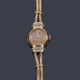 Lote 2566: UNIVERSAL Geneve de señora con caja y brazalete en oro rosa de 18 K con diamantes.