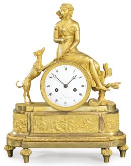 Lote 1259: Reloj de sobremesa imperio en bronce dorado. Sobre basamento elíptico se sitúa la esfera del reloj, firmada Brisbart con númeración romana. Encima de ella, Diana cazadora.